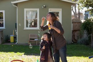 Mom, Julie blowing bubbles with autistic daughter