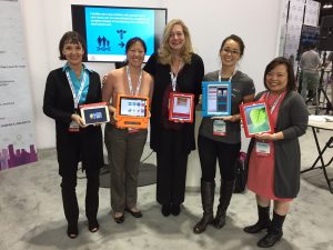 Five women standing holding iPads