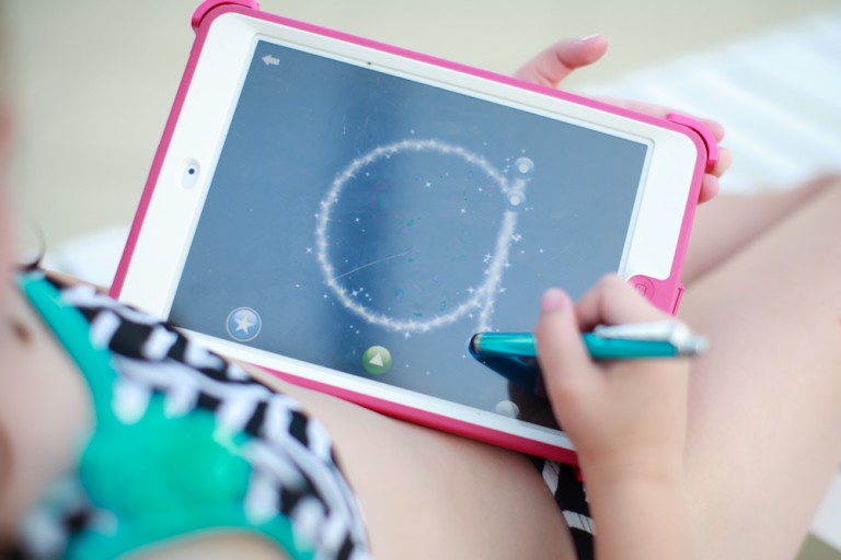 Child writing on an ipad