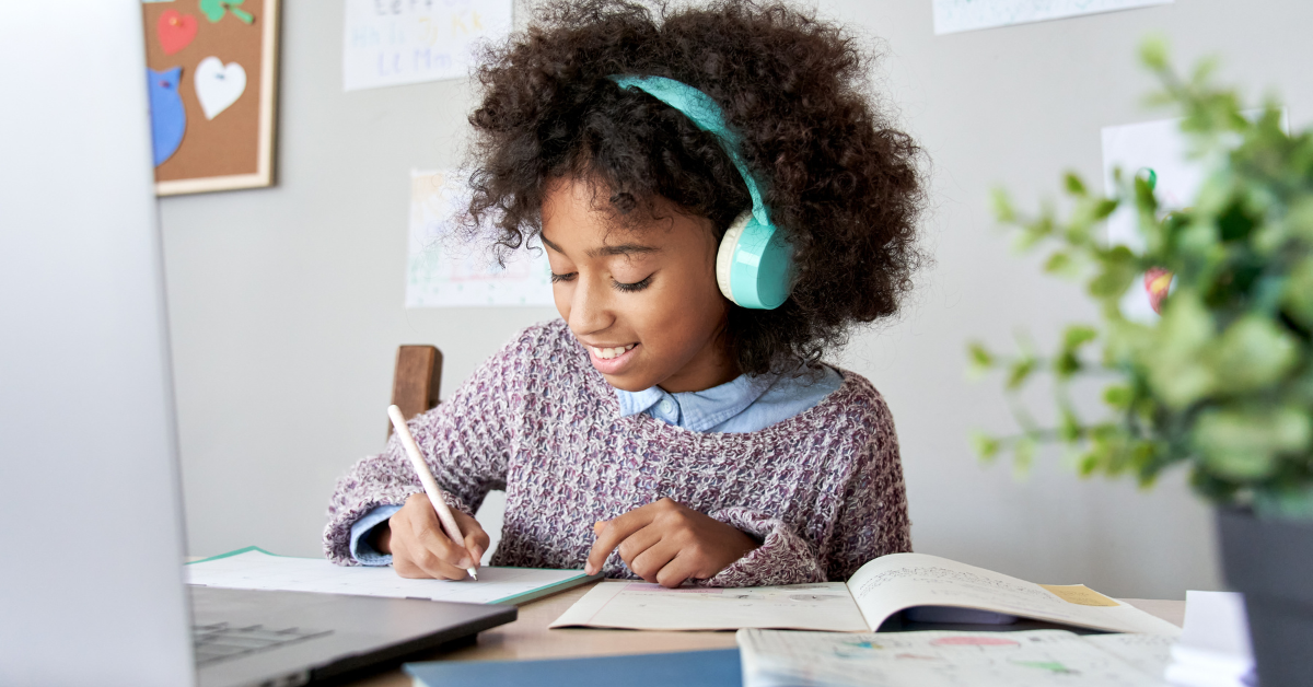 tween girl doing homework at laptop