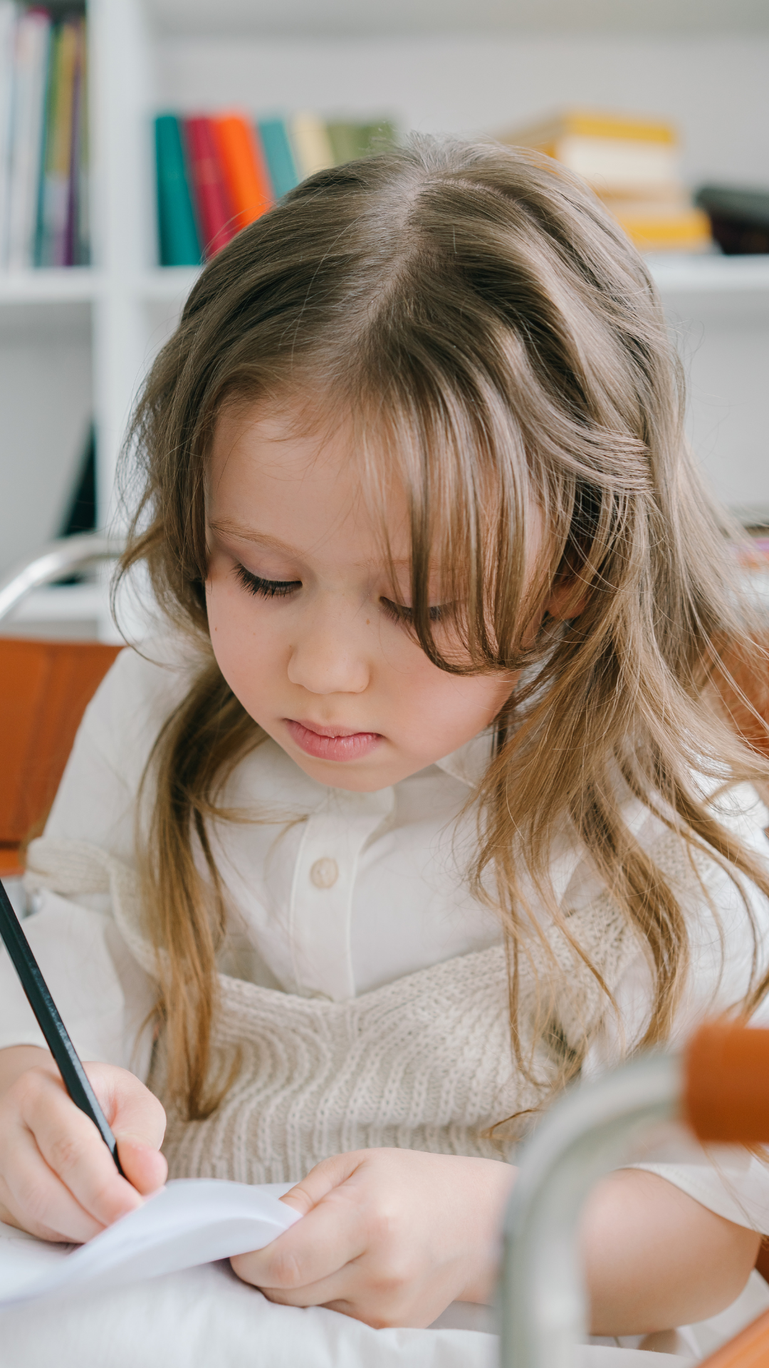 young girl sitting at desk writing