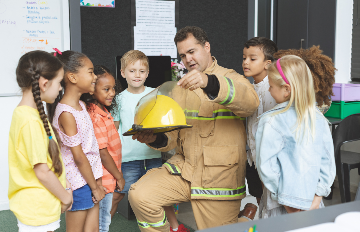 fire fighter teaching young children fire safety