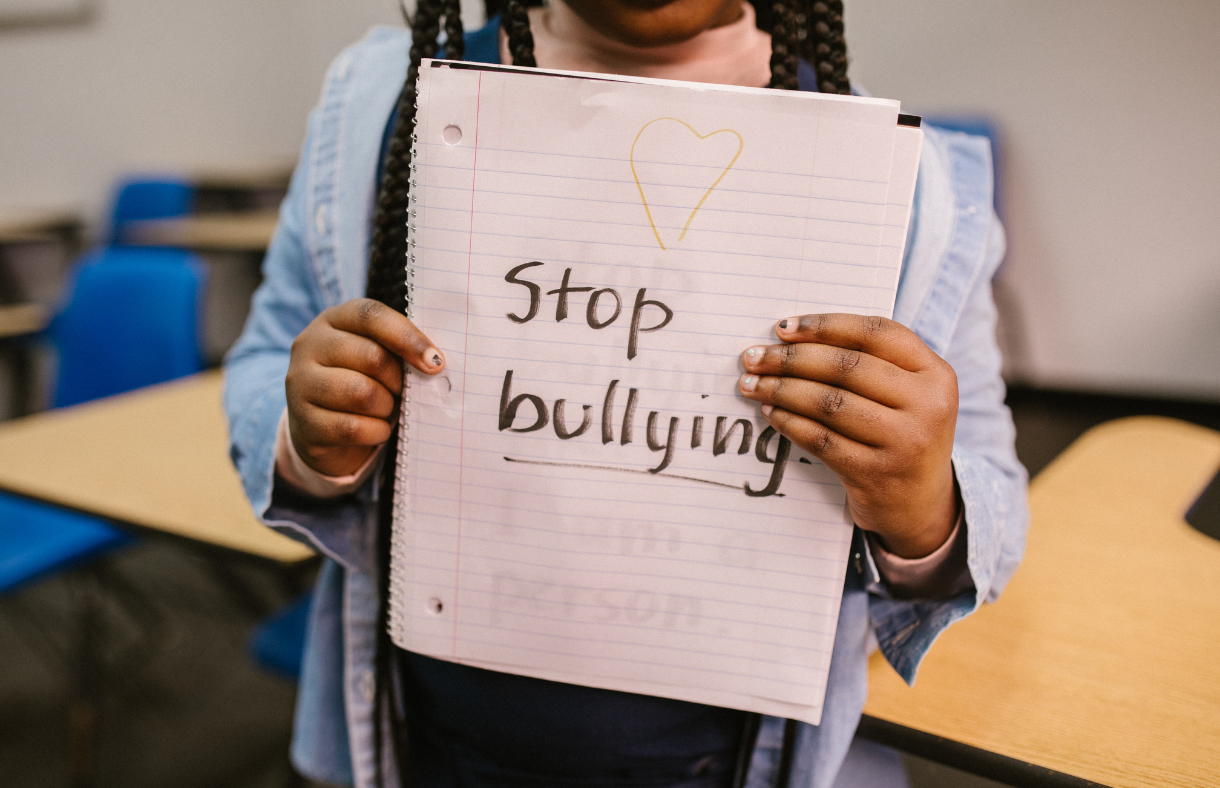 child holding paper that says stop bullying