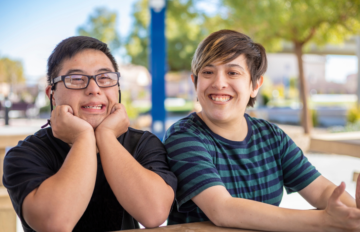 two friends sitting at a picnic table at the park