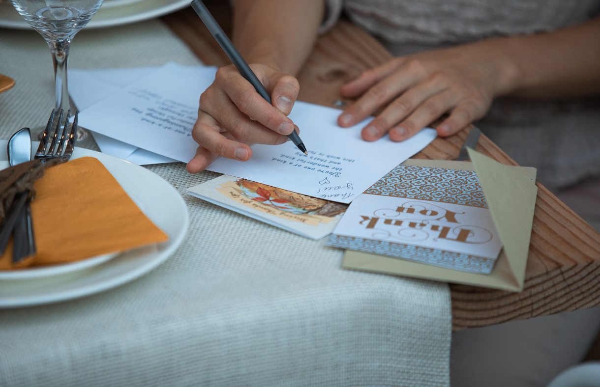 hands writing thank you note