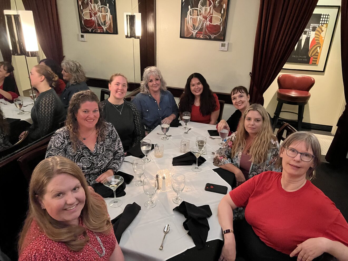 group of 8 smiling ladies at restaurant table