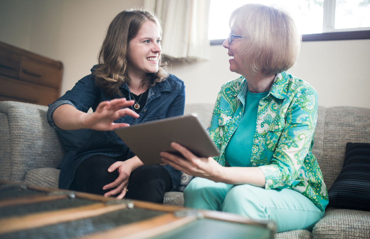 young lady helping older adult female use ipad