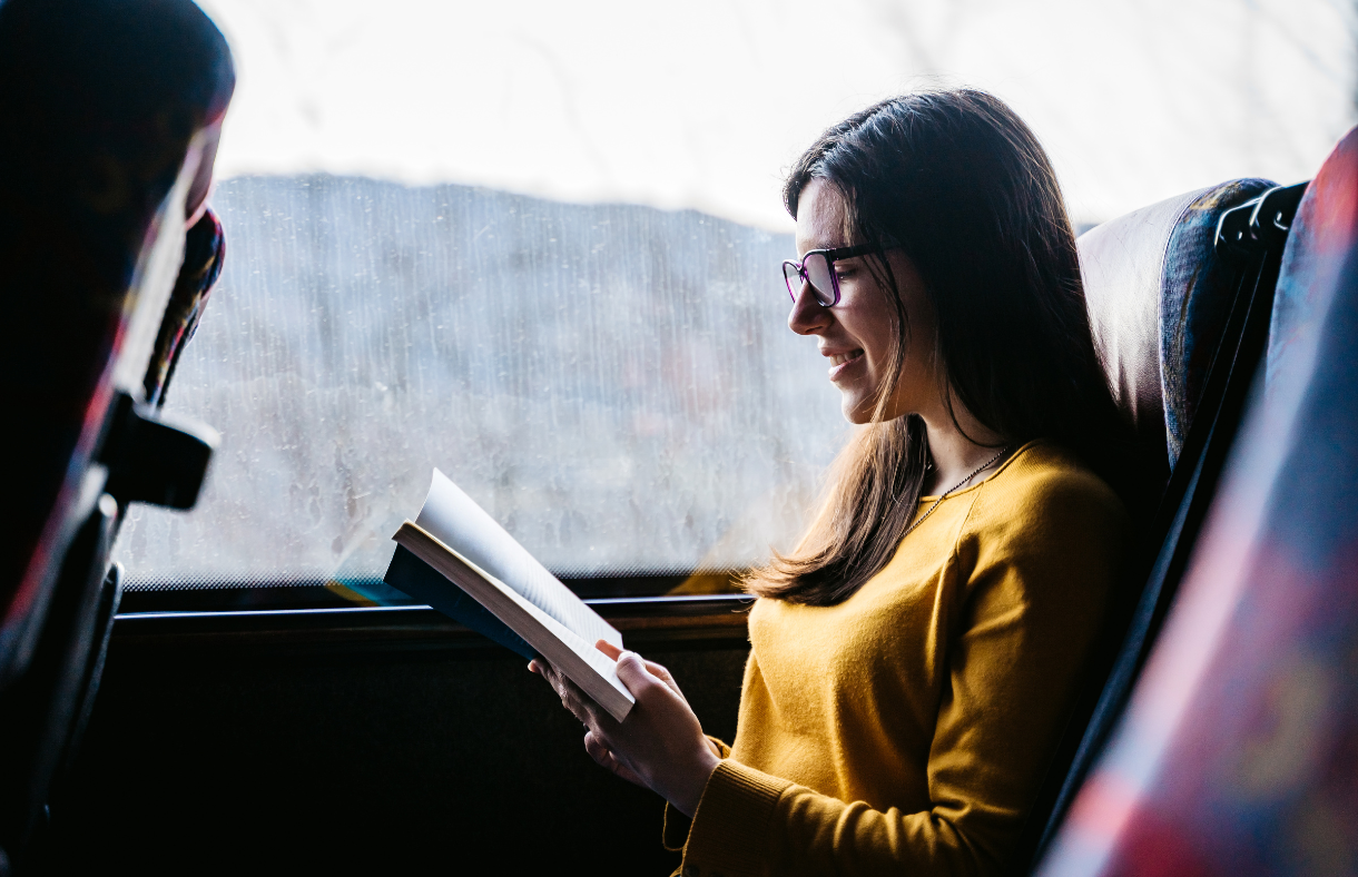 lady reading book on bus