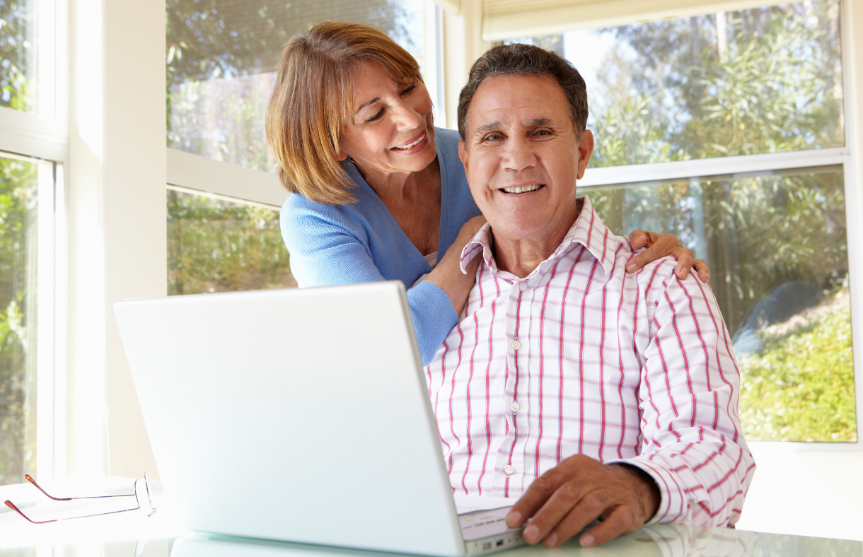 older adult couple sitting in front of computer