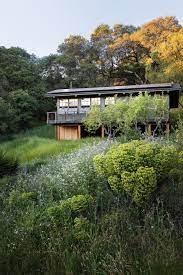 Two-story retreat house in brushy clearing.