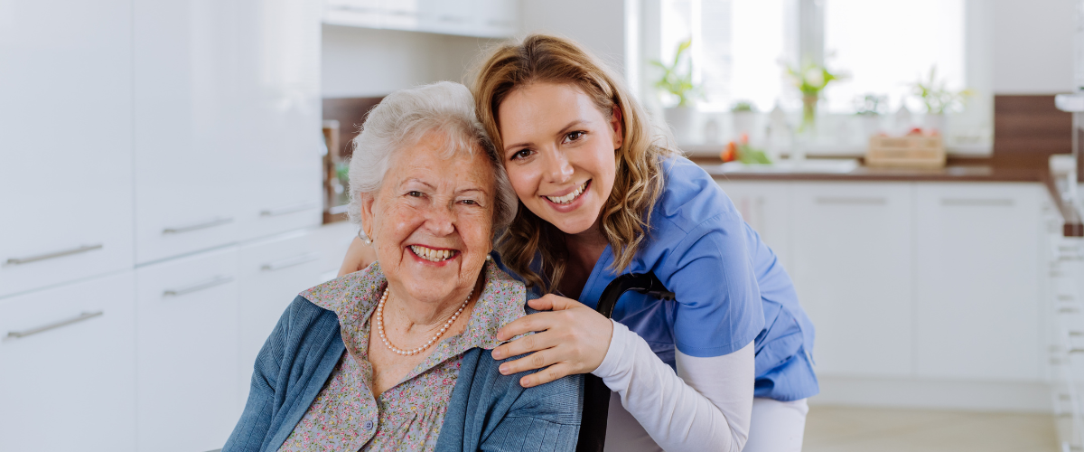 caregiver smiling with older adult woman