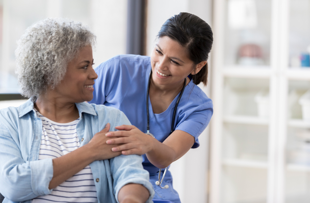 nurse helping older adult woman