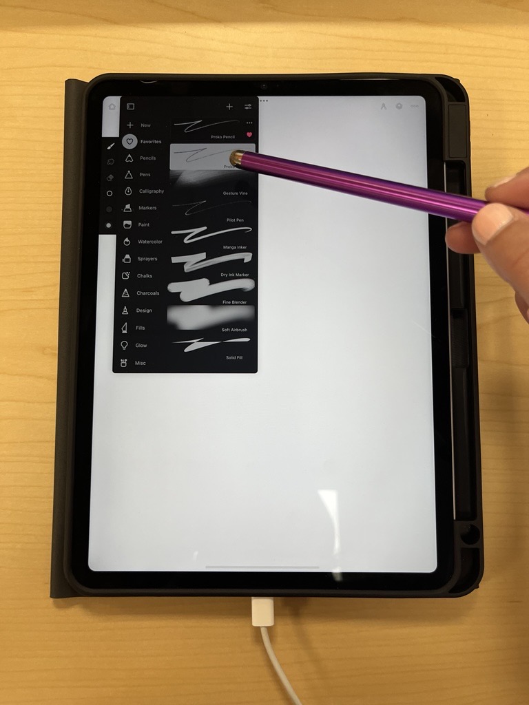 Picture of a hand drawing wavy lines on a black-and-white screen with a purple stylus. Drawing-styles menu showing on left of screen.