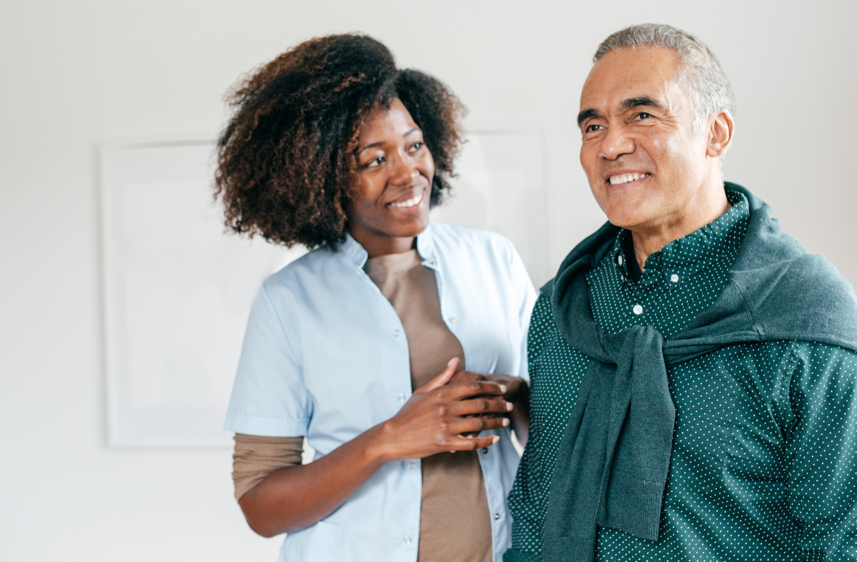 woman standing next to older man, both smiling