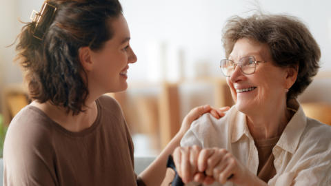 adult woman caregiver helping older adult