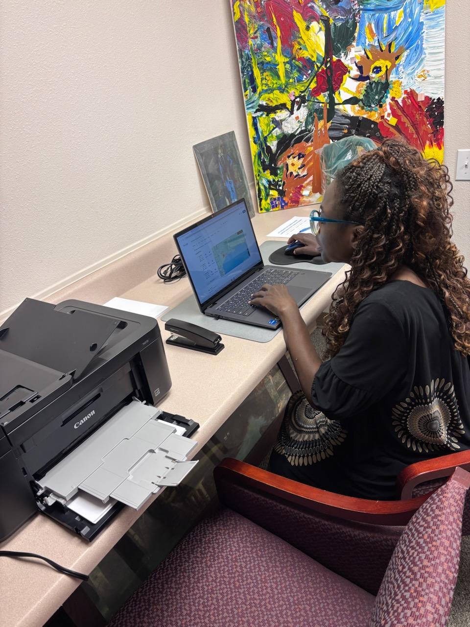 woman sitting at desk using laptop