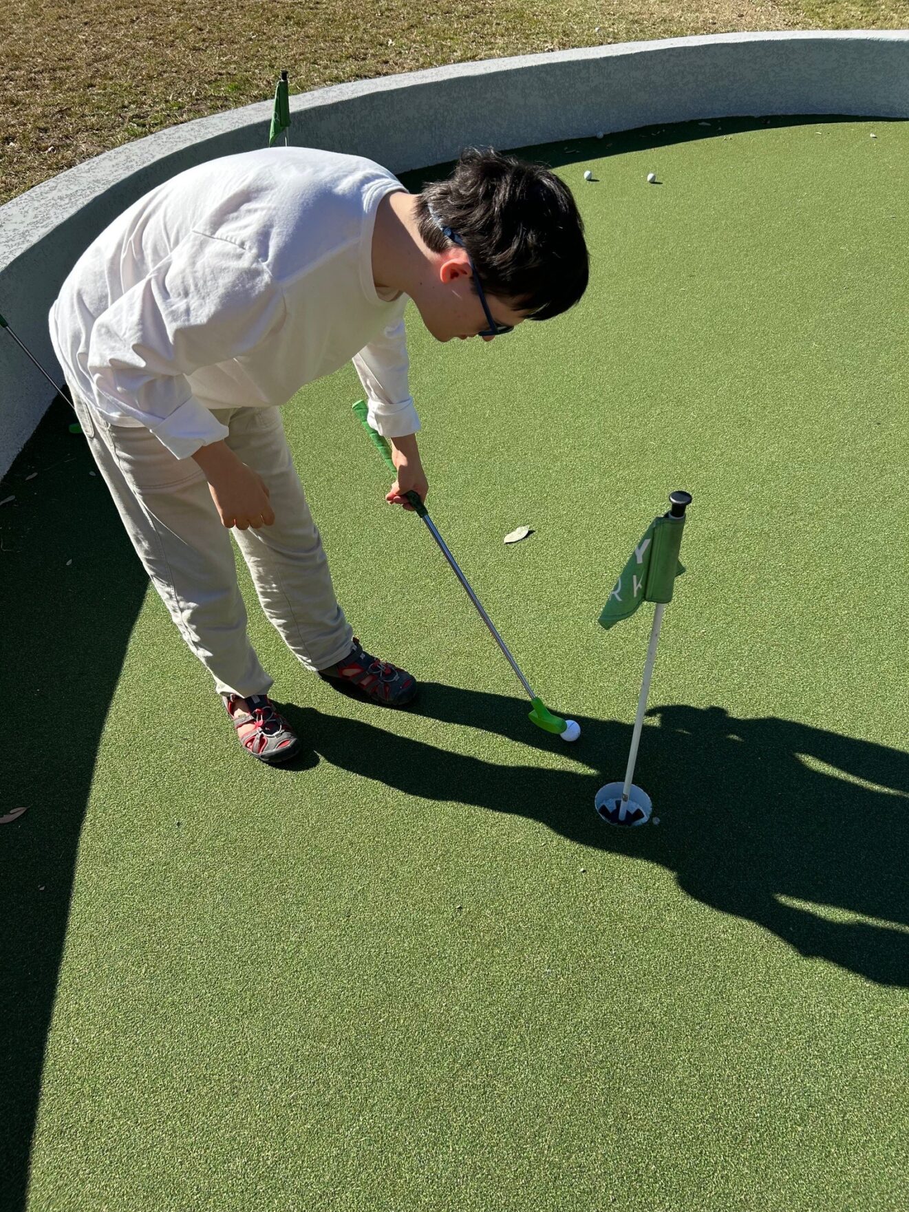 young adult guy playing putt putt