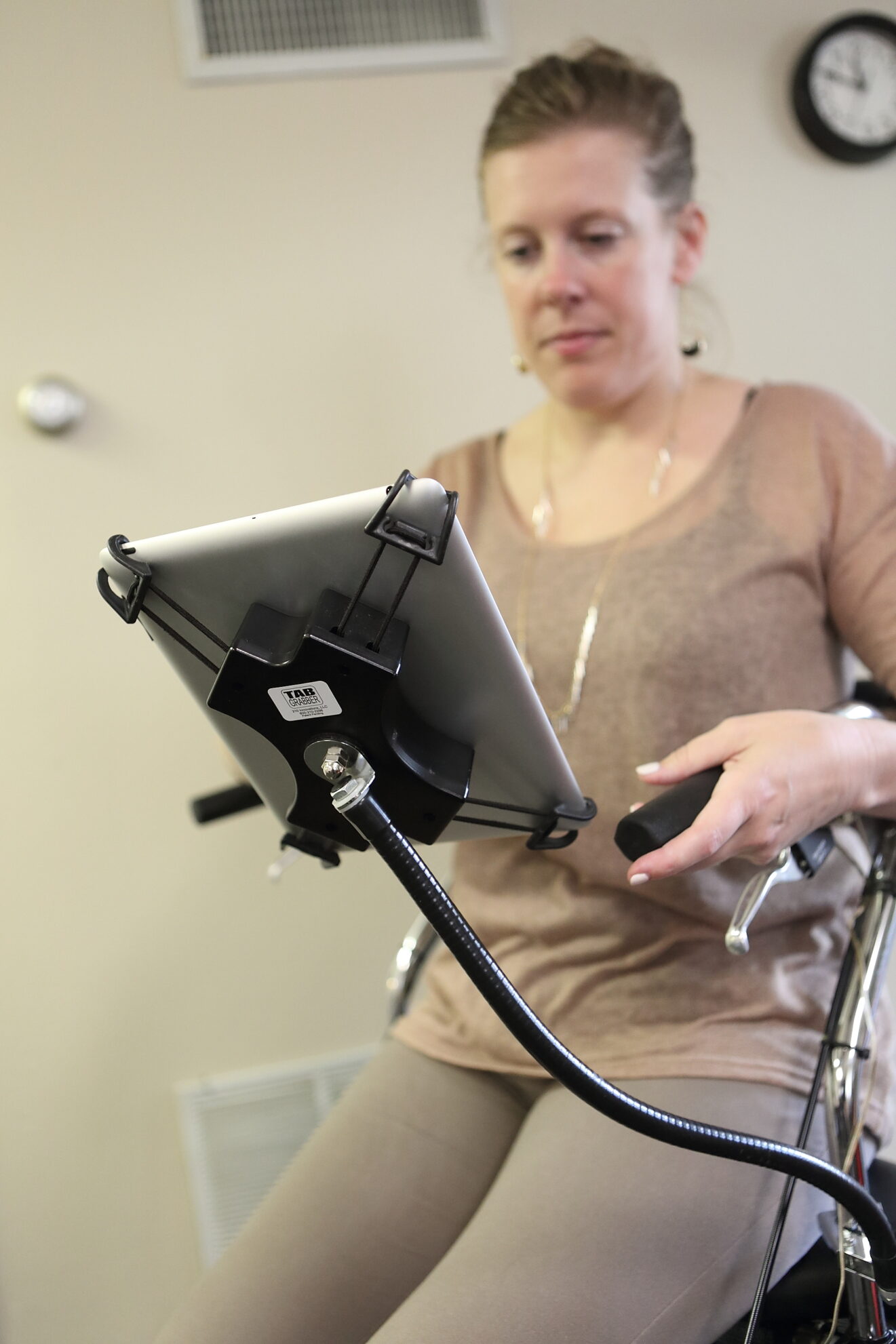 Images of woman sitting on walker using attached mobile device