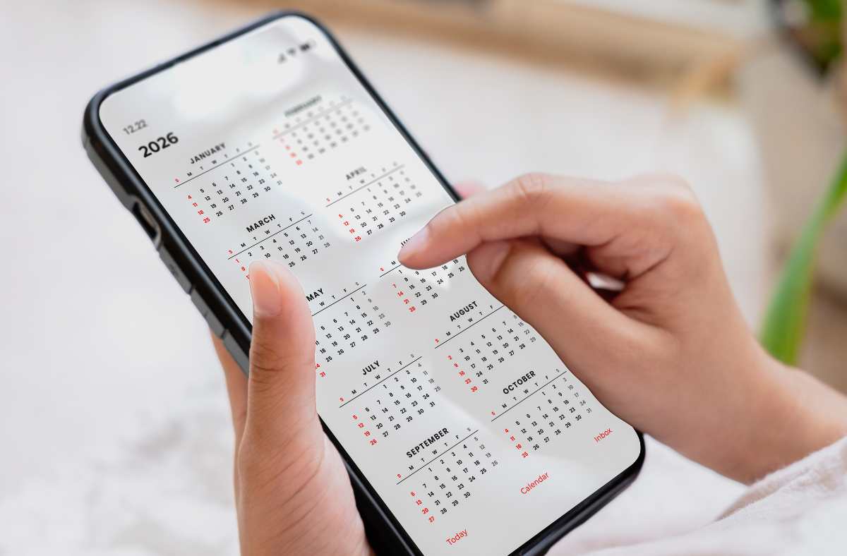 close up of hands holding phone with 2026 digital calendar