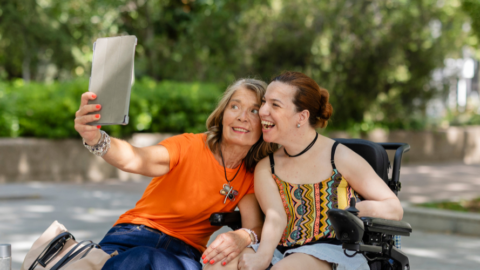 woman in wheelchair taking selfie w friend