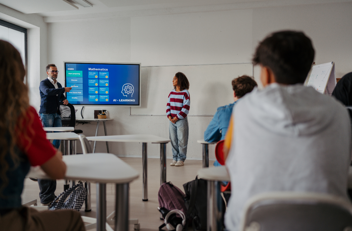 teens in classroom w AI learning display on smart board