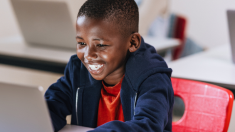boy in school using laptop
