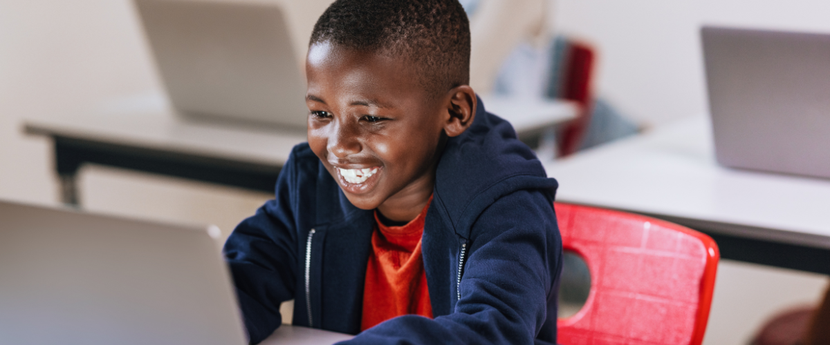 boy in school using laptop