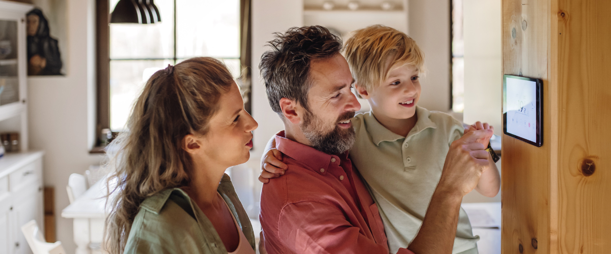 family looking at smart home device on wall