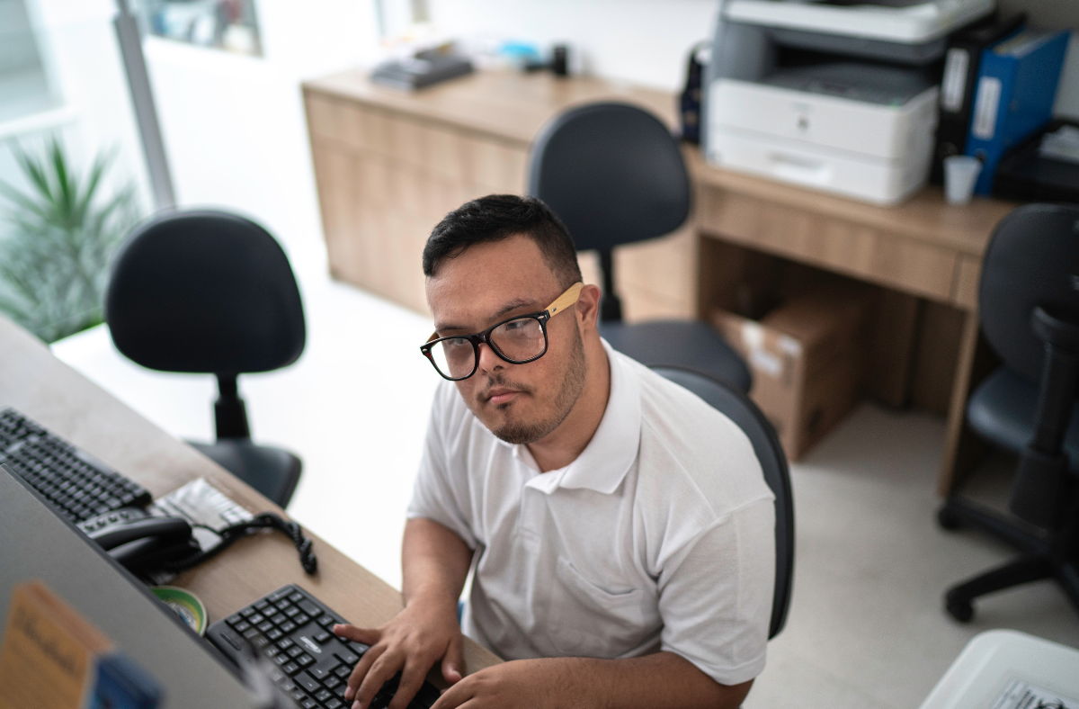 young man in office working at computer typing on keyboard